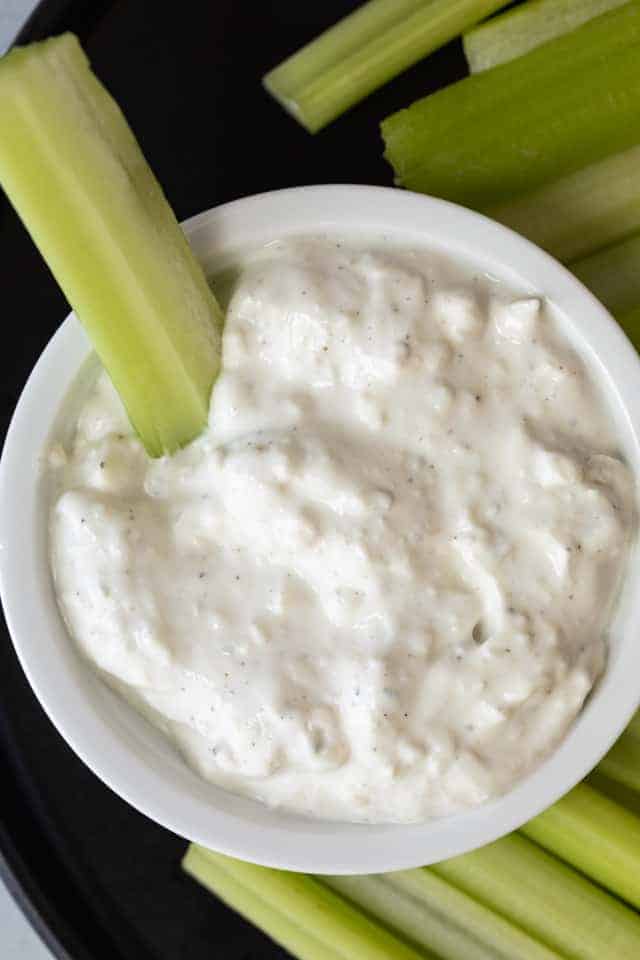 A bowl of blue cheese sauce served with celery