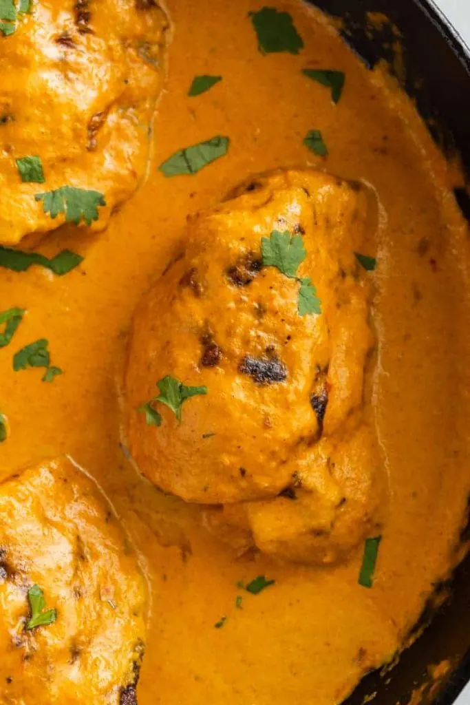 Overhead of butter chicken sauce in a pan with chicken