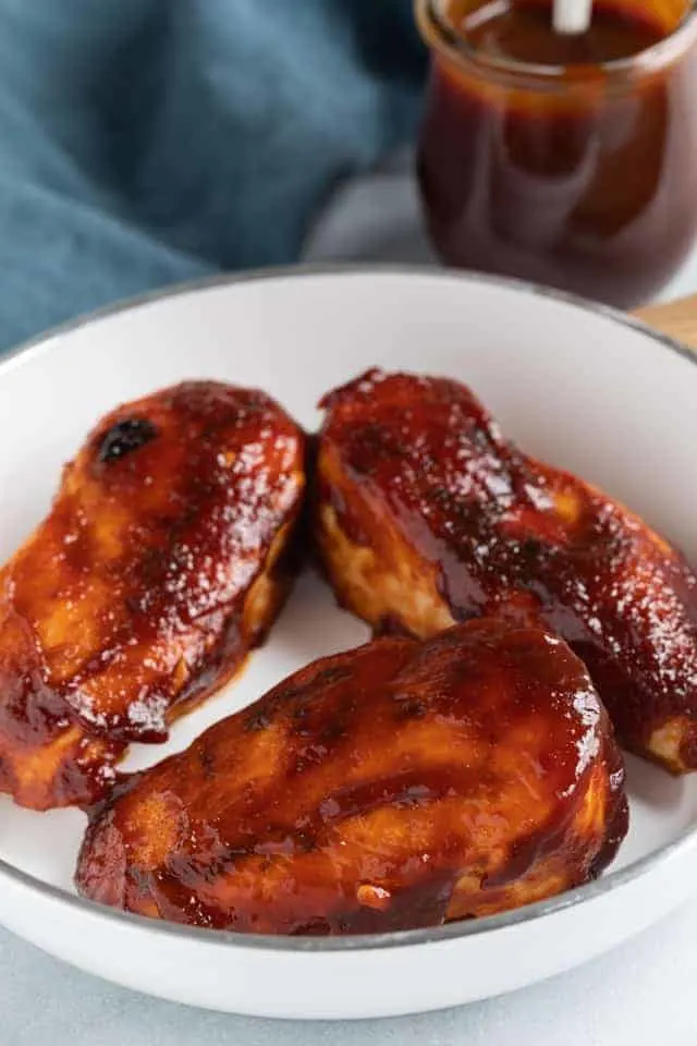 Chicken breasts coated in Jack Daniels sauce in a white pan