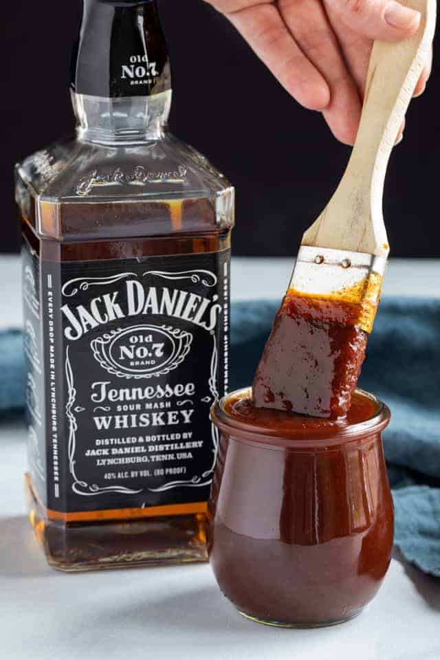 Jack Daniels sauce in a jar next to a bottle of Jack Daniels whiskey