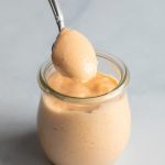 Yum Yum Sauce in a glass jar with a spoon
