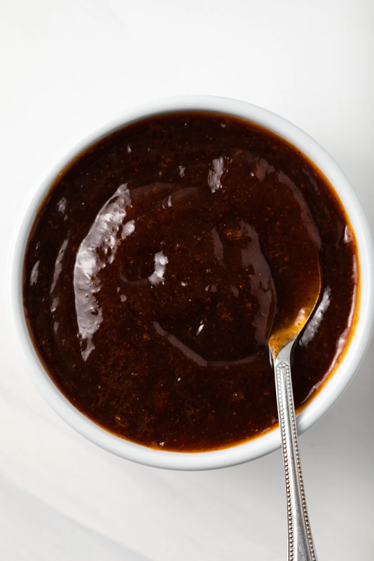 Overhead of apricot bbq sauce in white bowl.