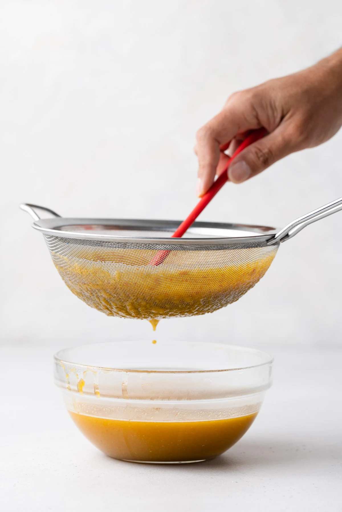 Straining ingredients through a sieve.