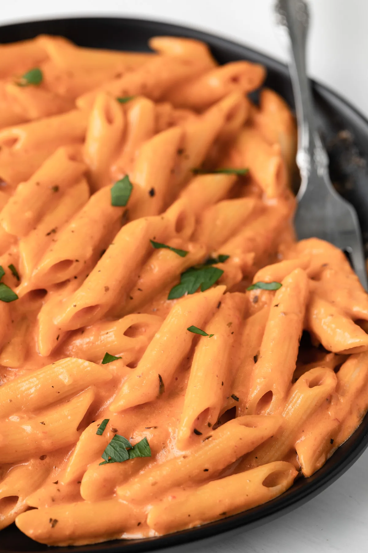 Close up of pasta coated in pink sauce.