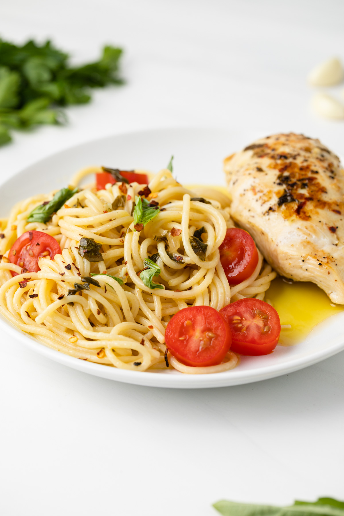 Angled view of pasta and chicken white plate.