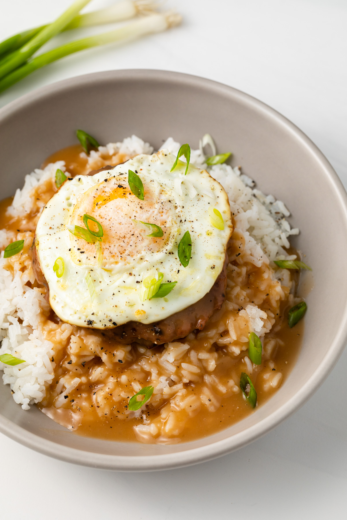 Rice, beef patty, egg, and Hawaiian brown gravy in a bowl.