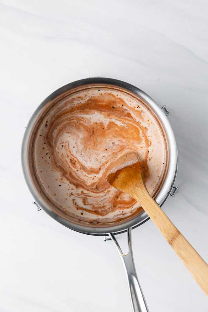 Cream stirred into vodka sauce.