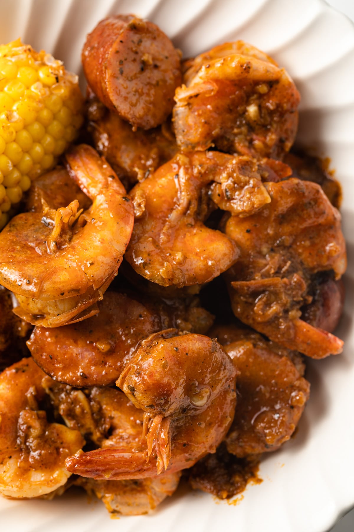 Closeup of cooked shrimp coated in boiling crab sauce.