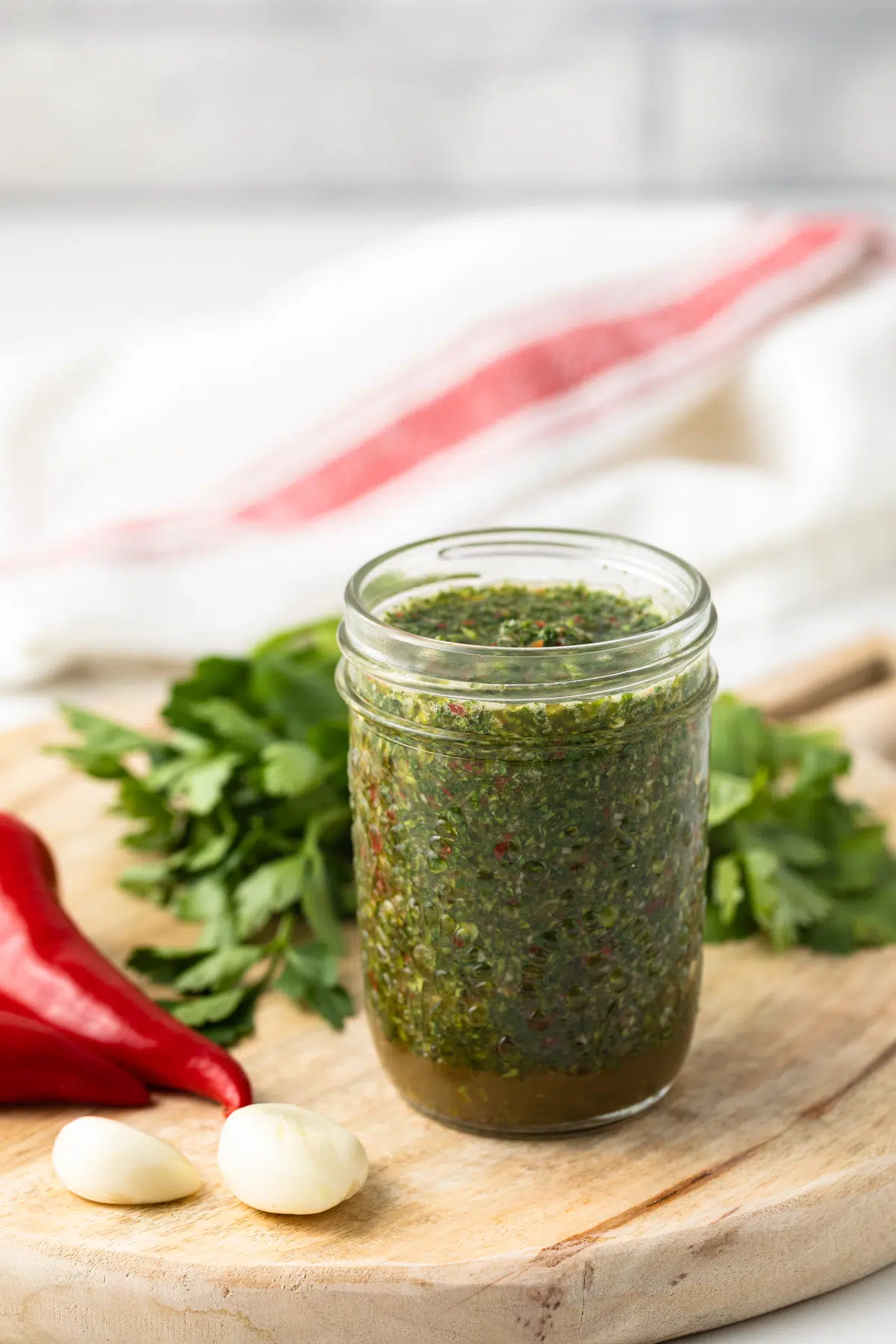 Cilantro chimichurri sauce in a glass jar.