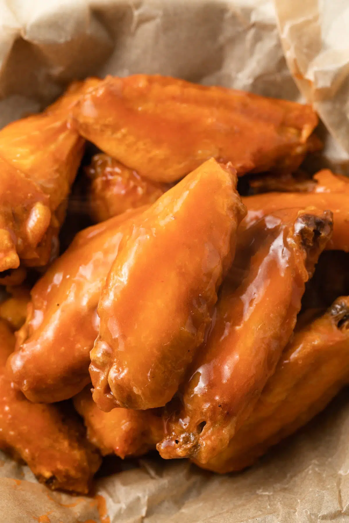Close up of wings coated in buffalo sauce.
