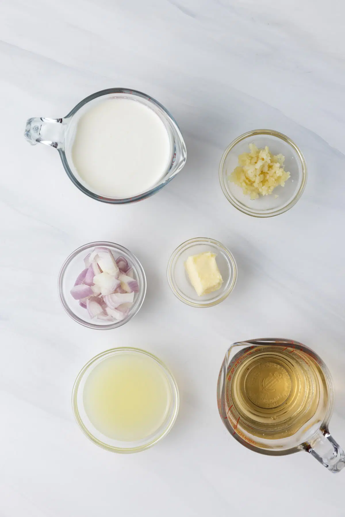 Ingredients for lobster ravioli sauce in glass bowls.