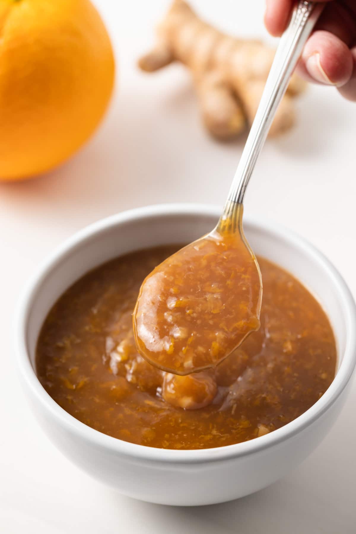 Orange ginger sauce on a spoon.