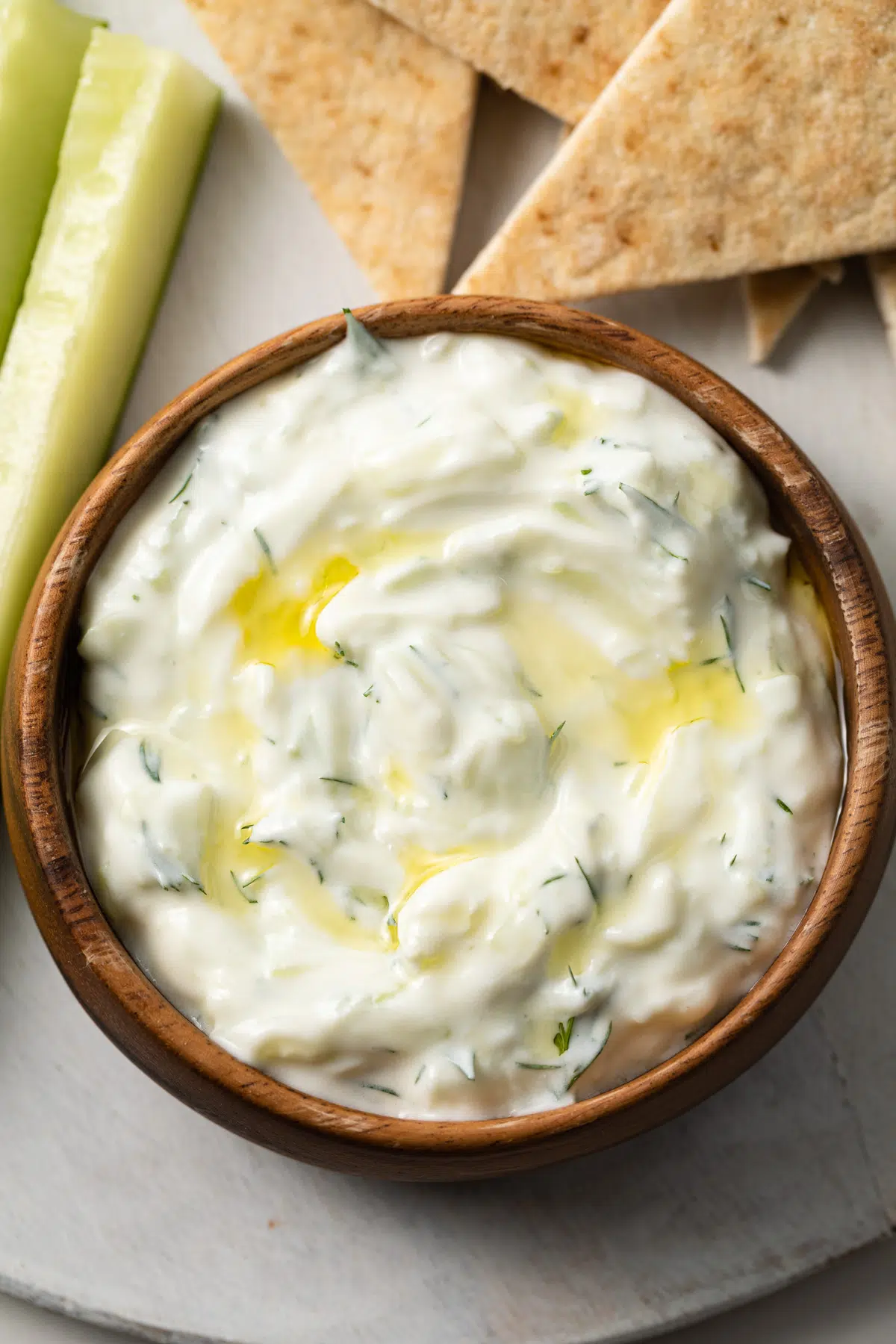 Close up of tzatziki sauce in wooden bowl.