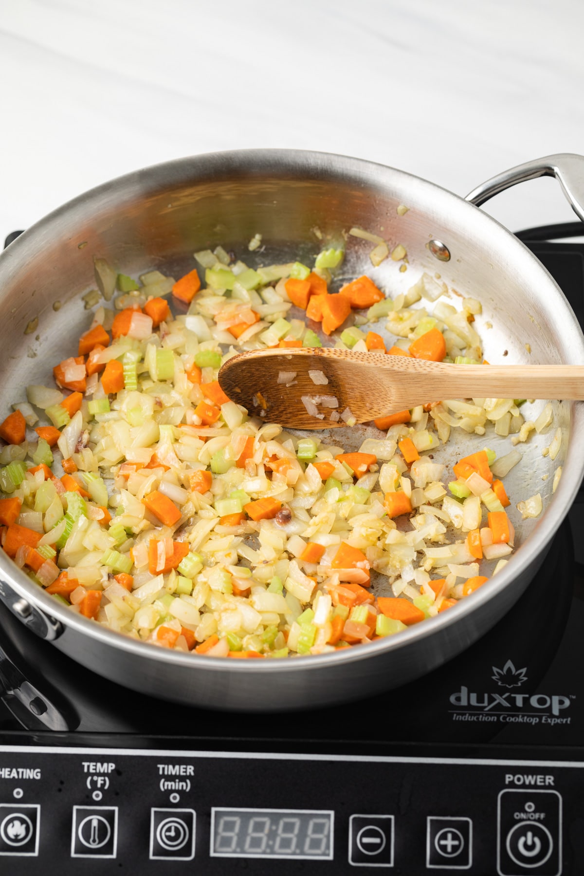 Carrots, onion, and celery cooked in saucepan.