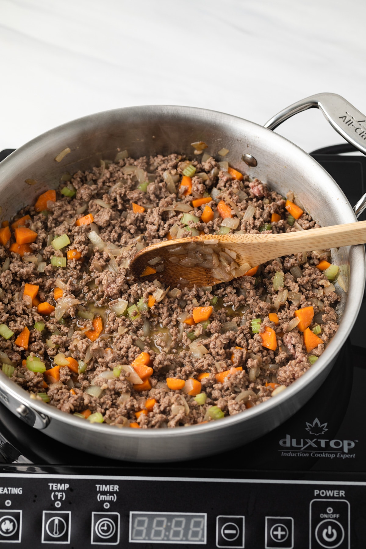 Meat added to veggies in saucepan.