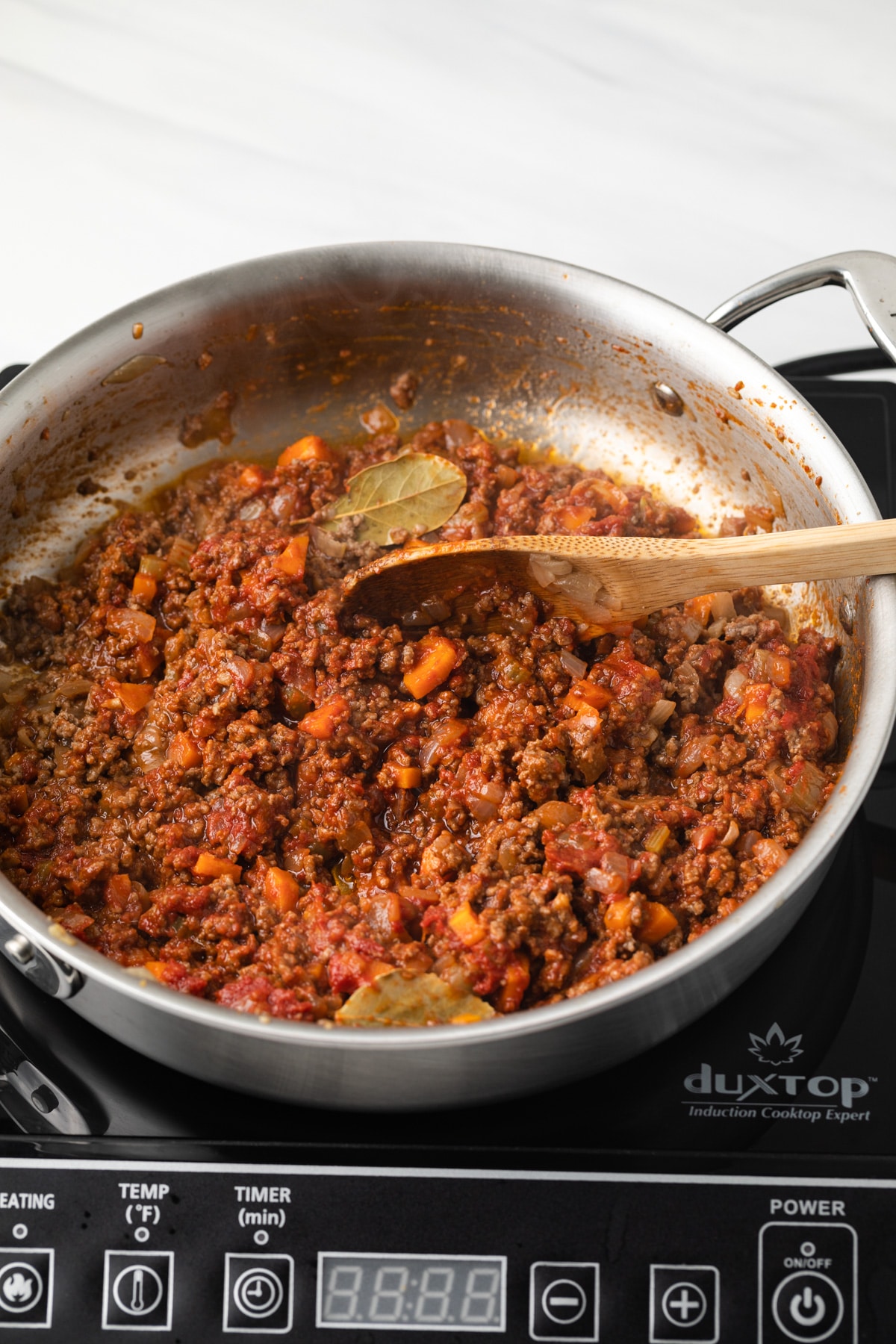 Tomato pasted added to meat and veggies in saucepan.