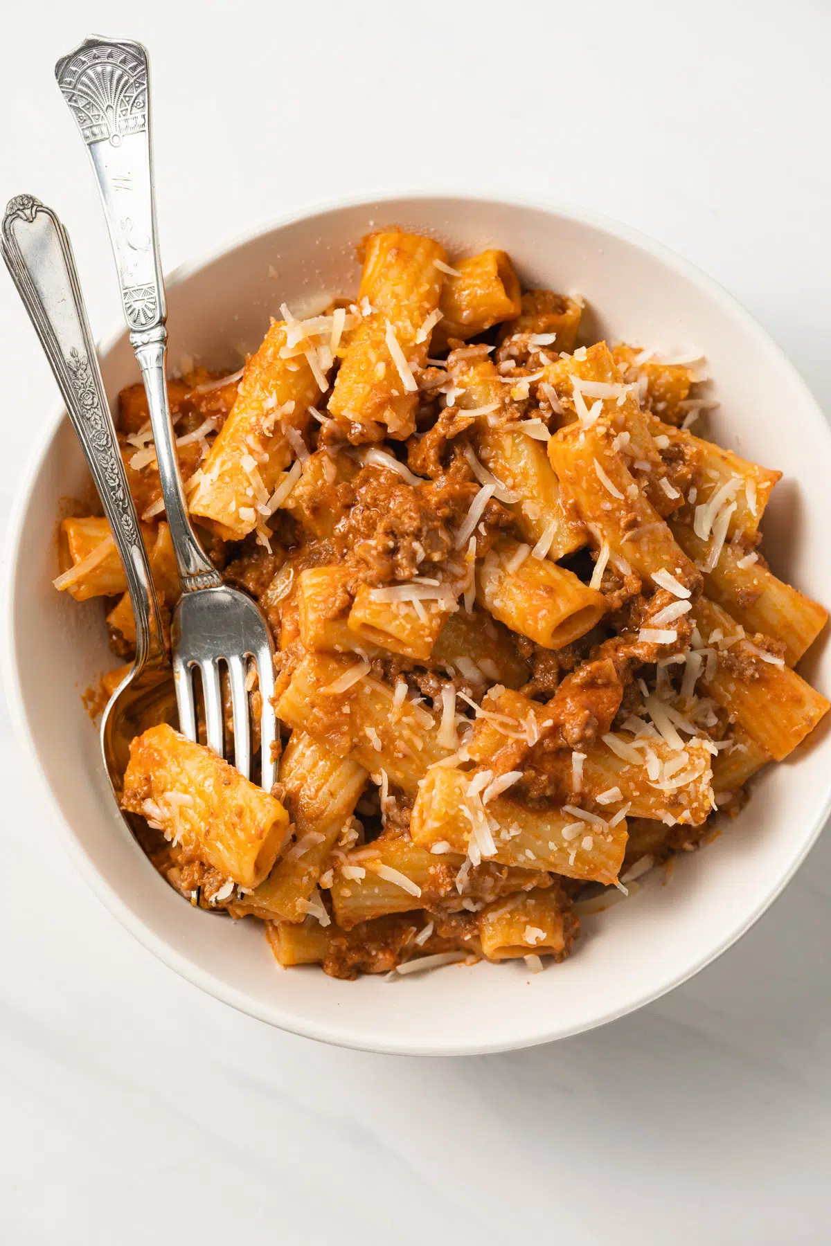 Bolognese meat sauce over rigatoni in bowl.