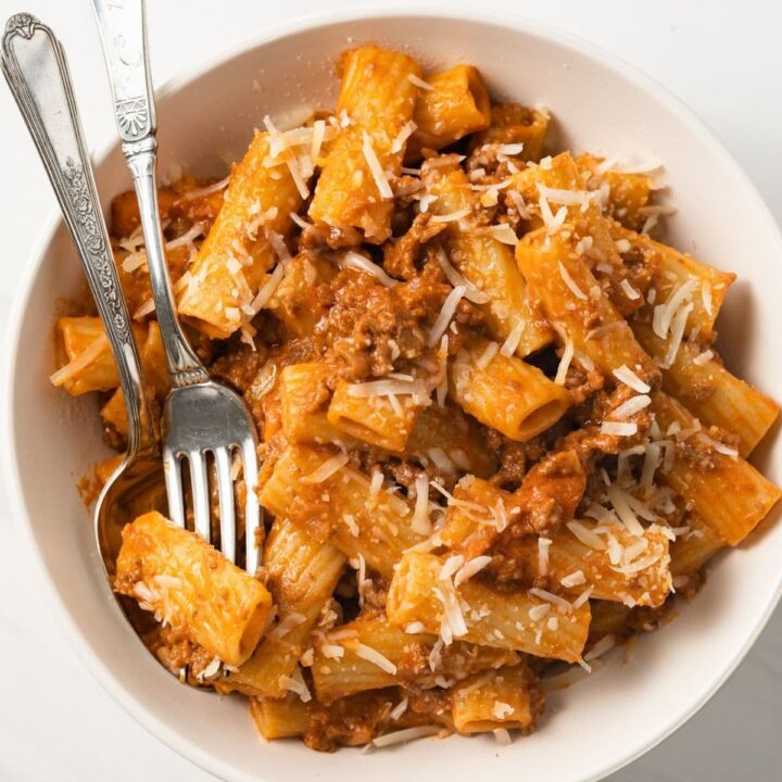 Bolognese meat sauce over rigatoni in bowl.