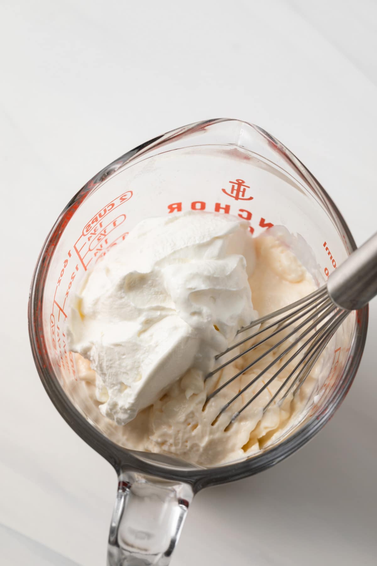 Mayonnaise and sour cream in glass measuring cup.