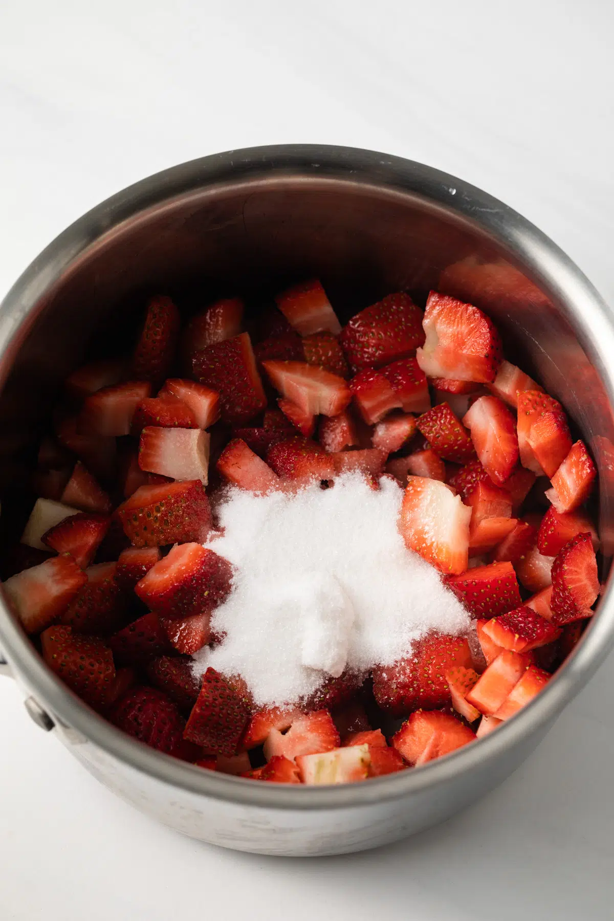 Strawberries and sugar in a pot.