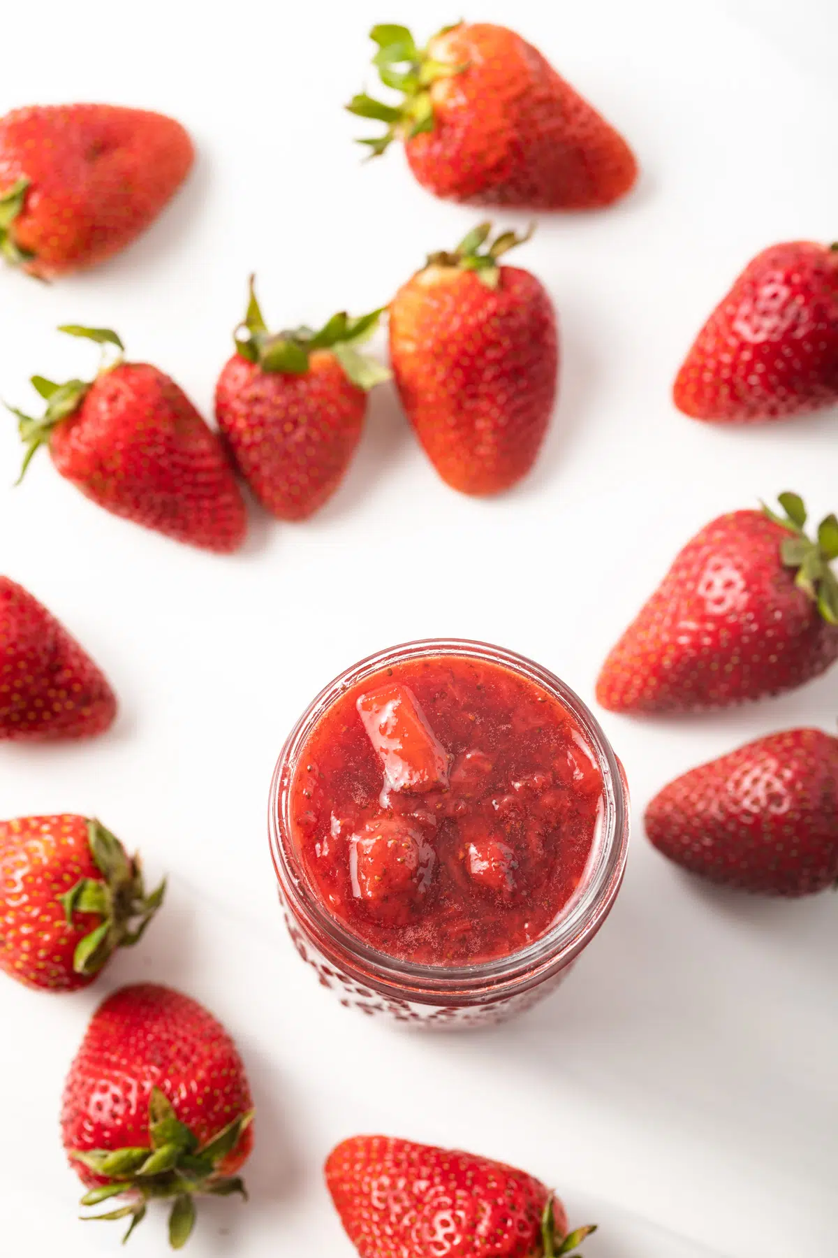 Overhead of strawberry sauce in a jar.