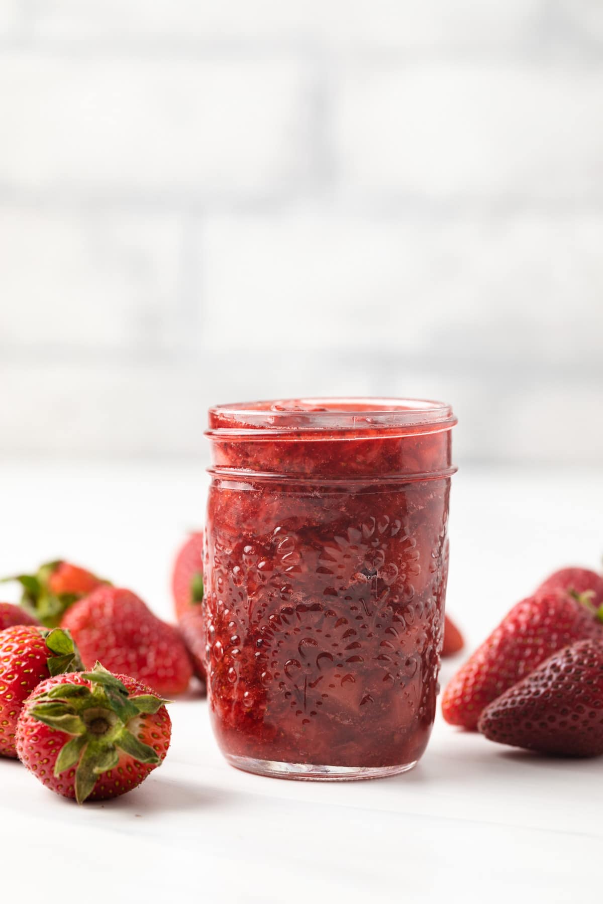 Side view of strawberry sauce in a jar.