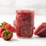 Side view of strawberry sauce in a jar.