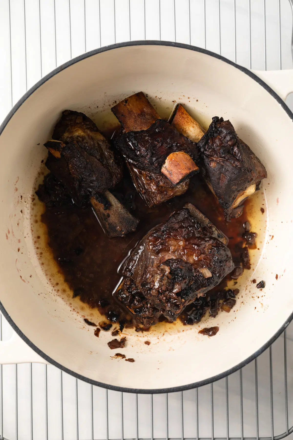 Cooked beef short ribs and juices in large pot.