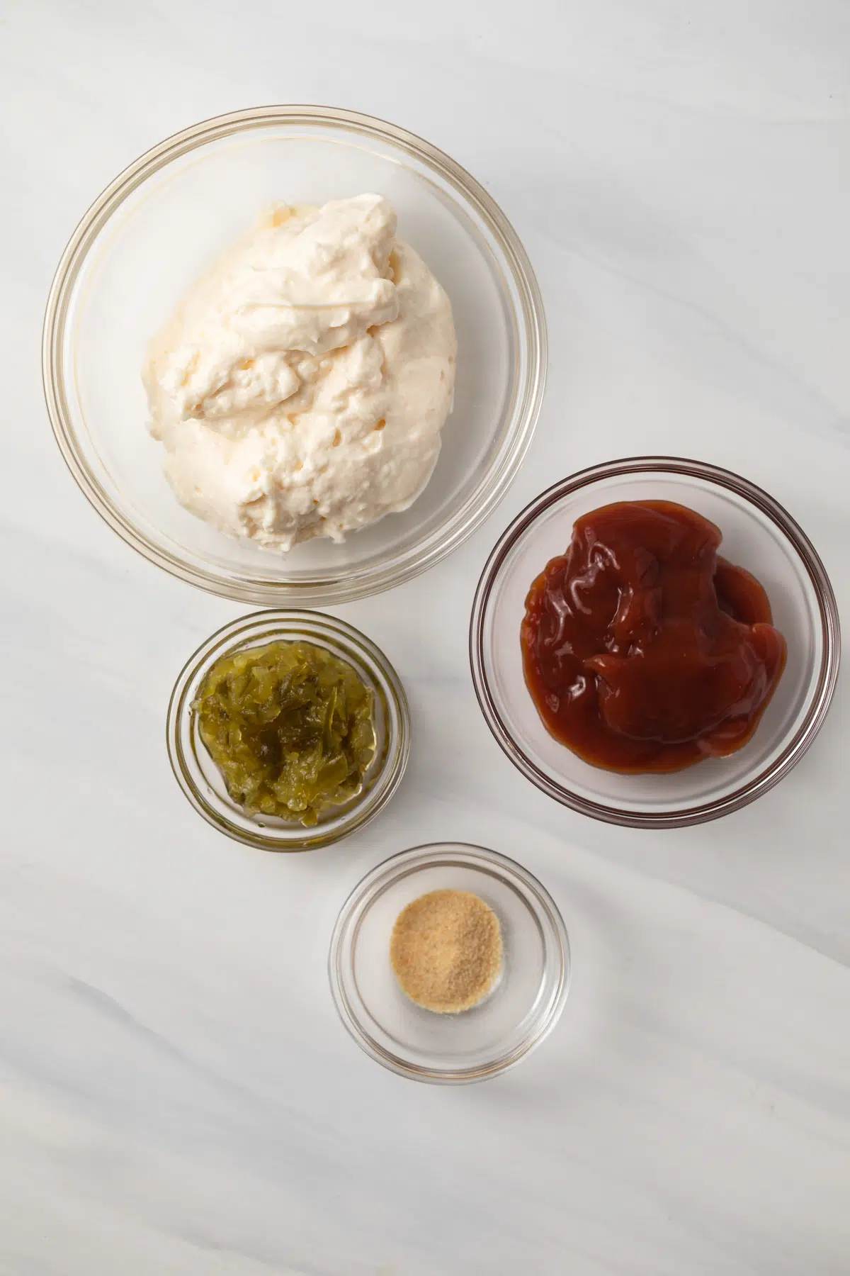 Ingredients for burger sauce in glass bowls.