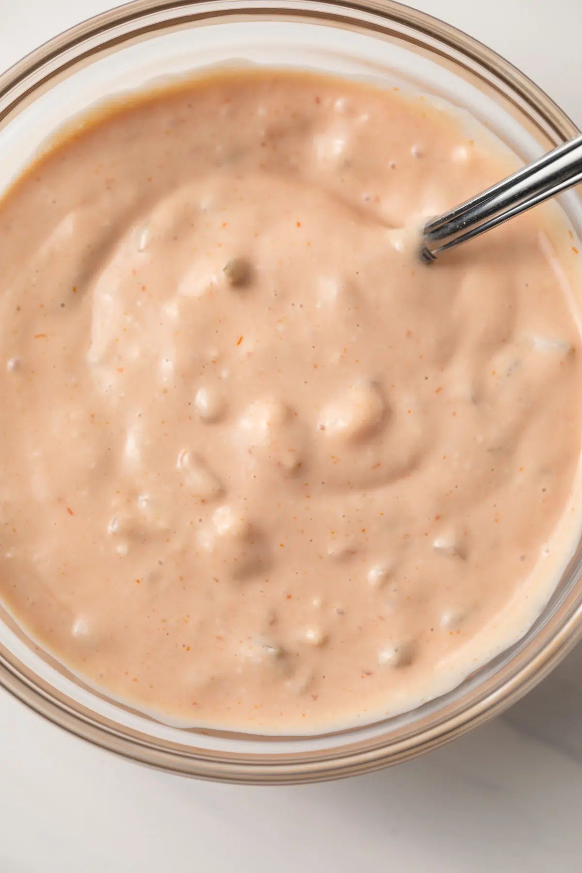 Close up of burger sauce in glass bowl with spoon.