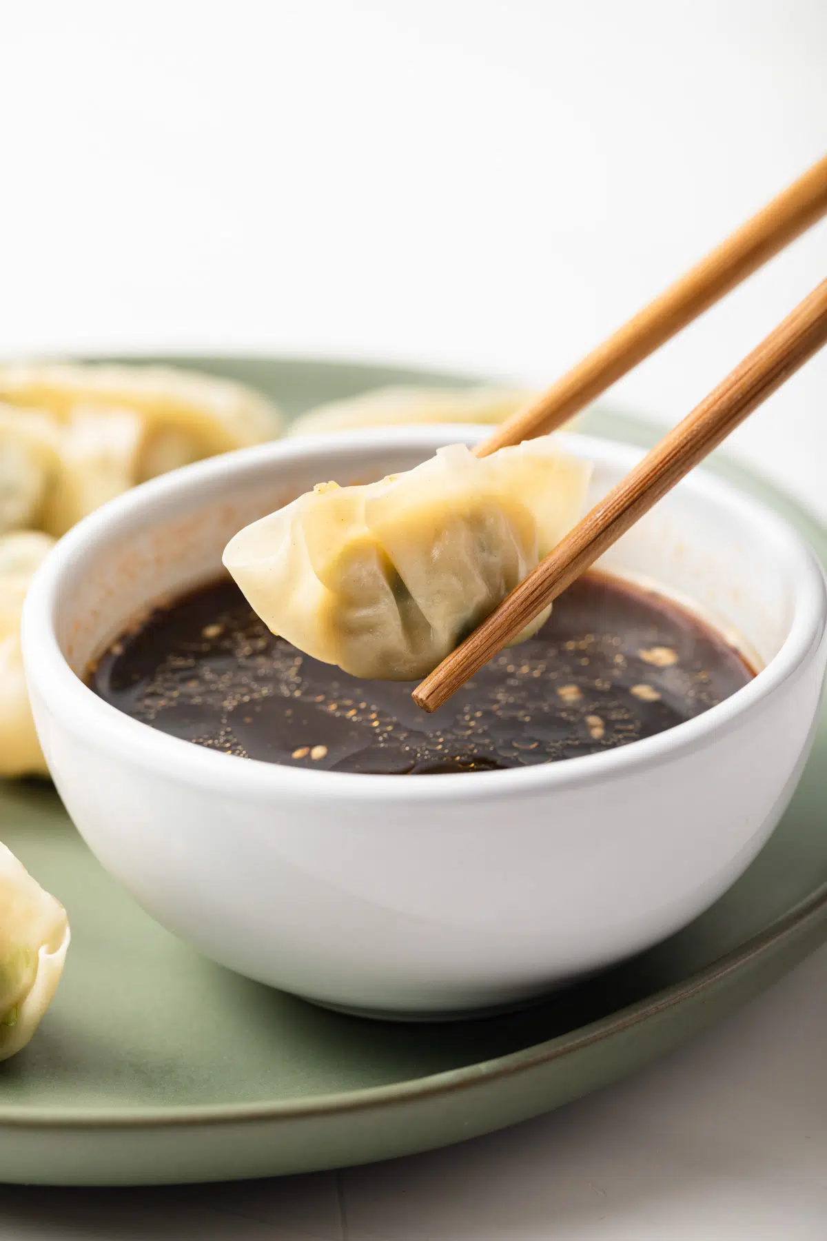 Dipping dumpling in dim sum dipping sauce.