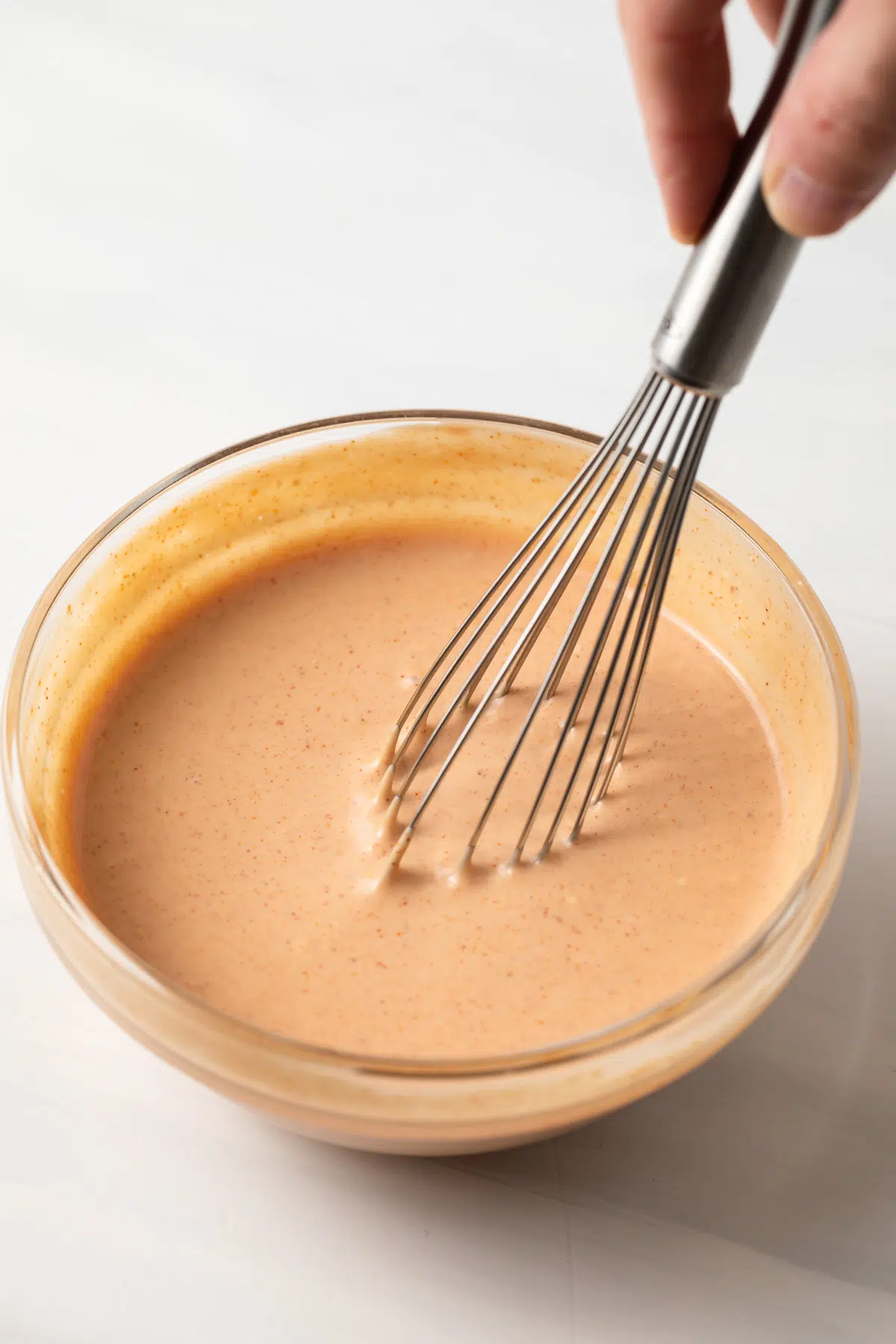 Whisking French fry sauce.