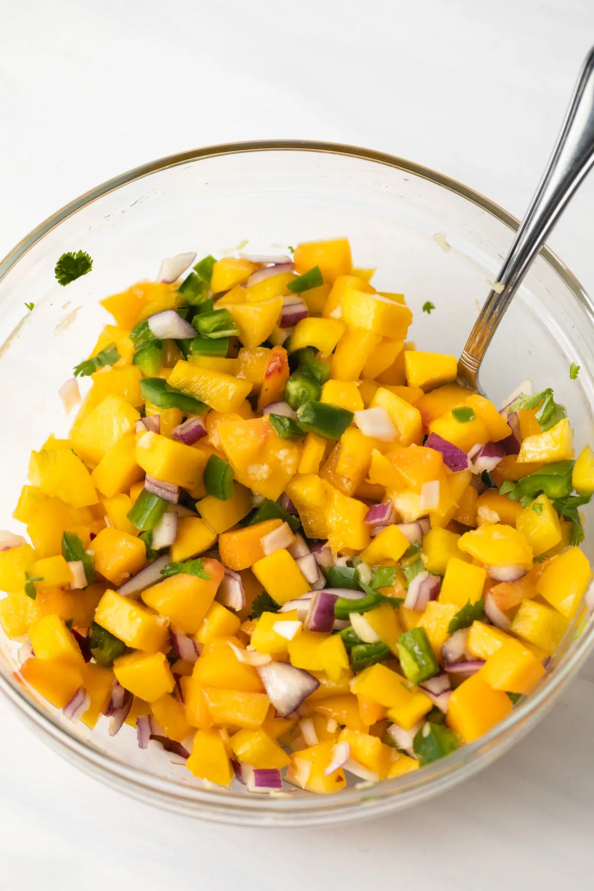 Peach mango salsa in glass bowl.