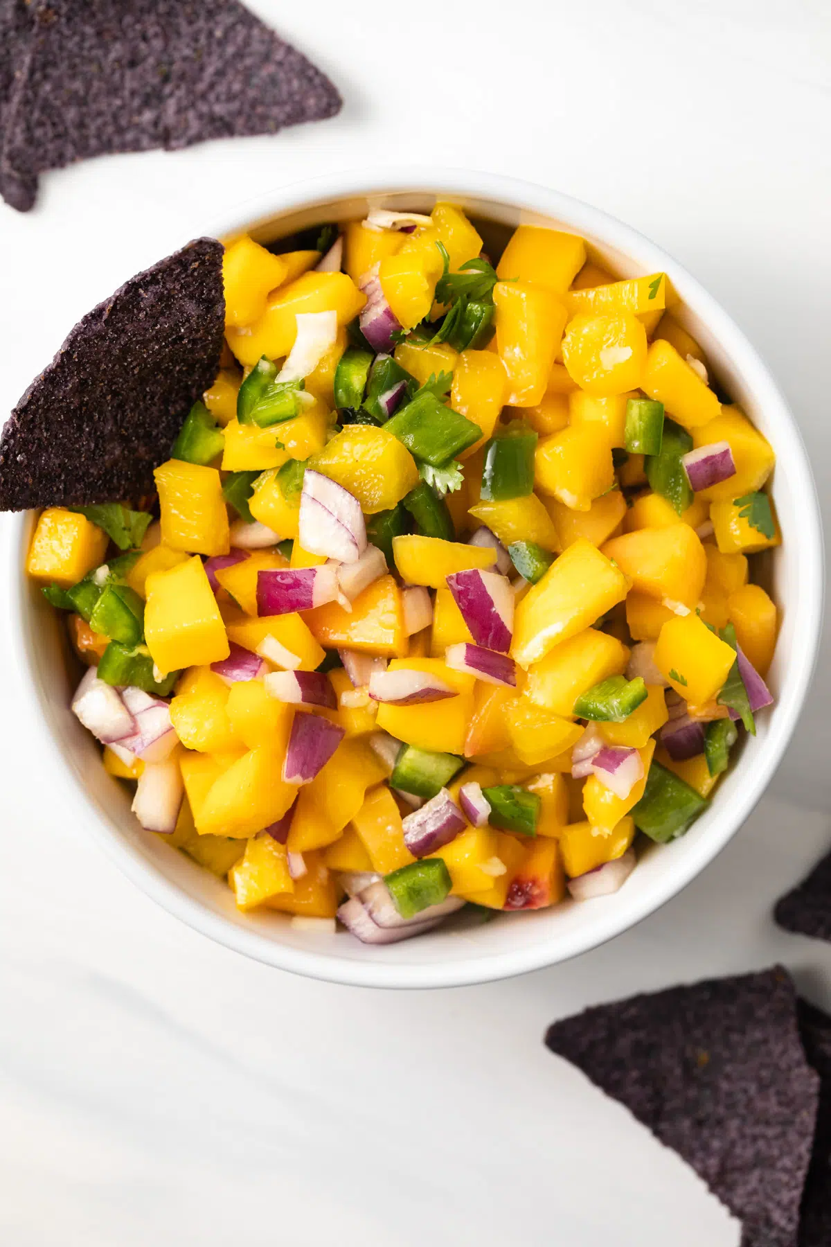 Bowl of peach mango salsa with tortilla chips.