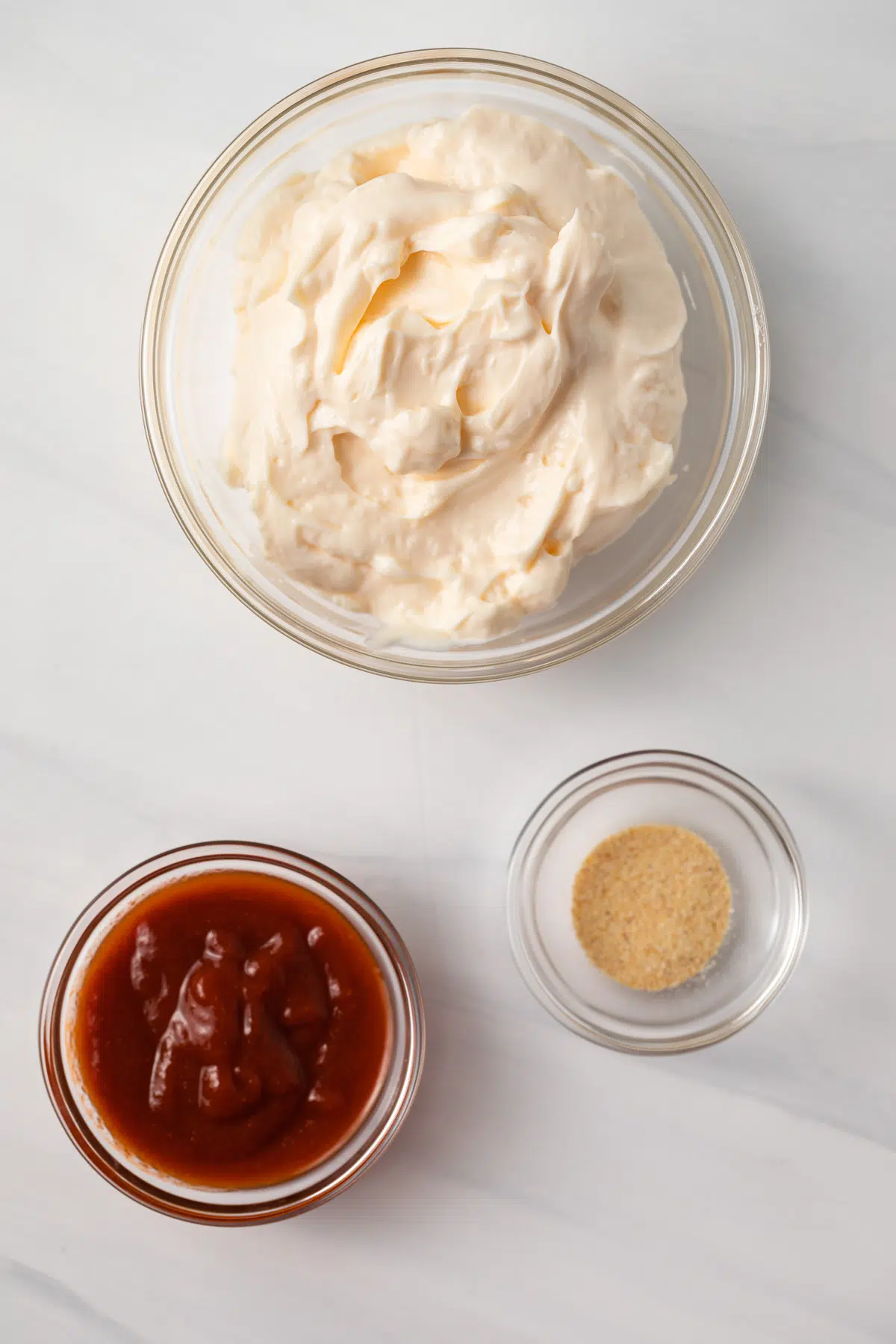 Ingredients for sriracha mayo in glass bowls.