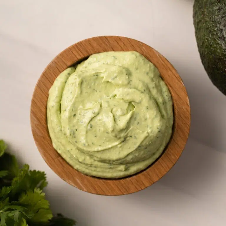Overhead of avocado crema in a wooden bowl.