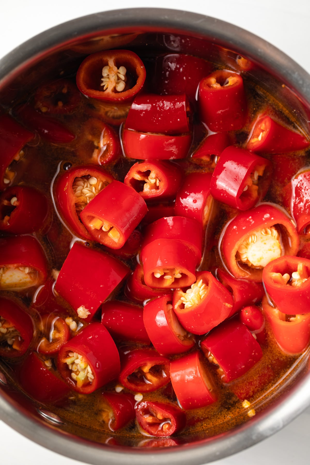 Chopped cayenne peppers in vinegar in a saucepan.