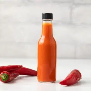 Cayenne pepper hot sauce in a glass jar.