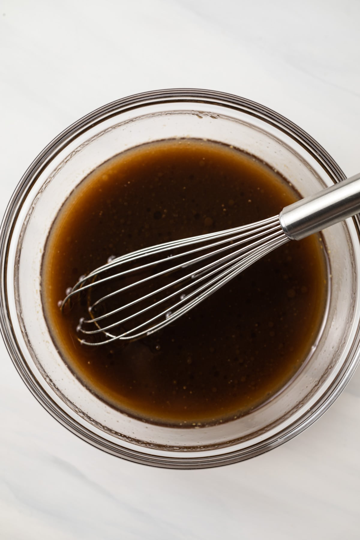 Honey Balsamic Vinaigrette in a glass bowl with whisk.
