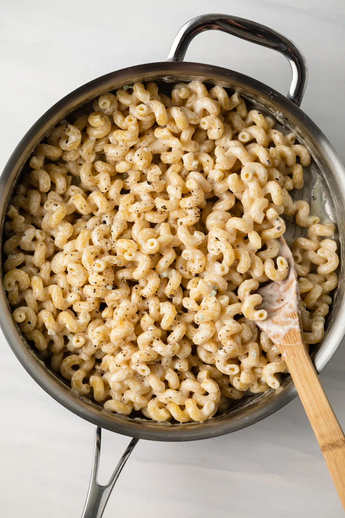 Pasta coated in lemon pepper garlic cream sauce in a skillet.