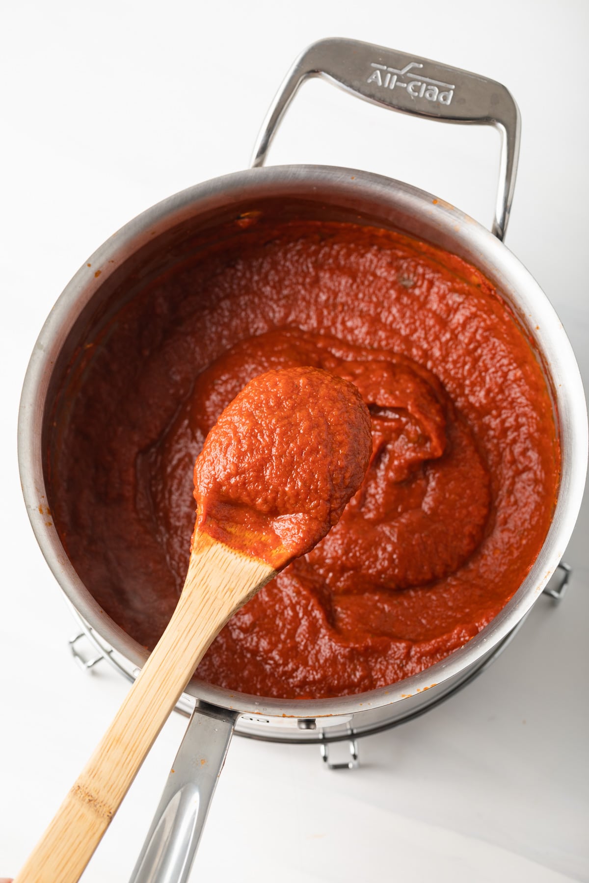 Pomodoro sauce in a saucepan with wooden spoon.