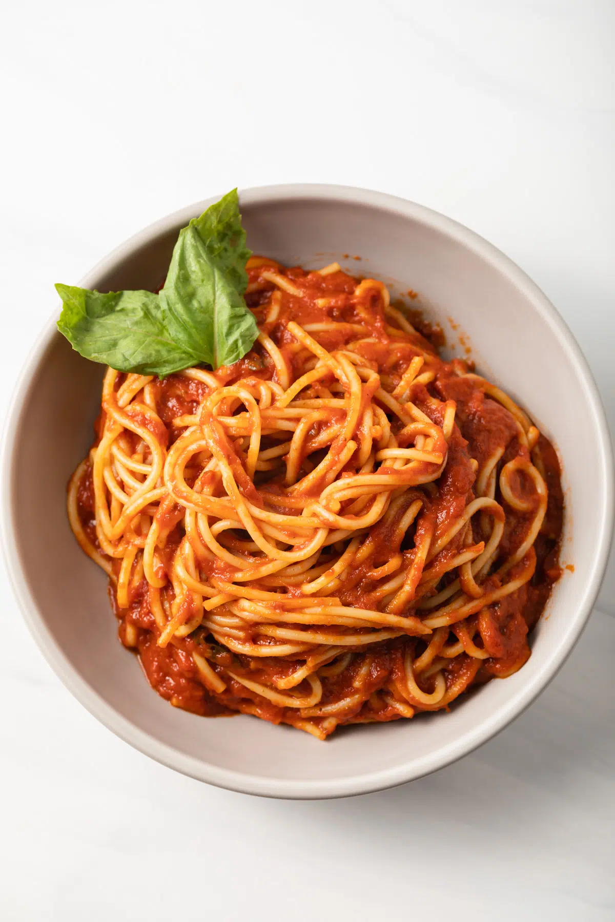 Overhead view of bowl of pasta coated in pomodoro sauce.