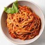 Overhead view of bowl of pasta coated in pomodoro sauce.