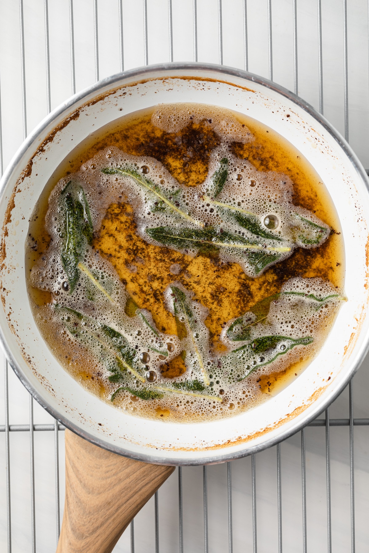 Sage butter sauce in a white fry pan.