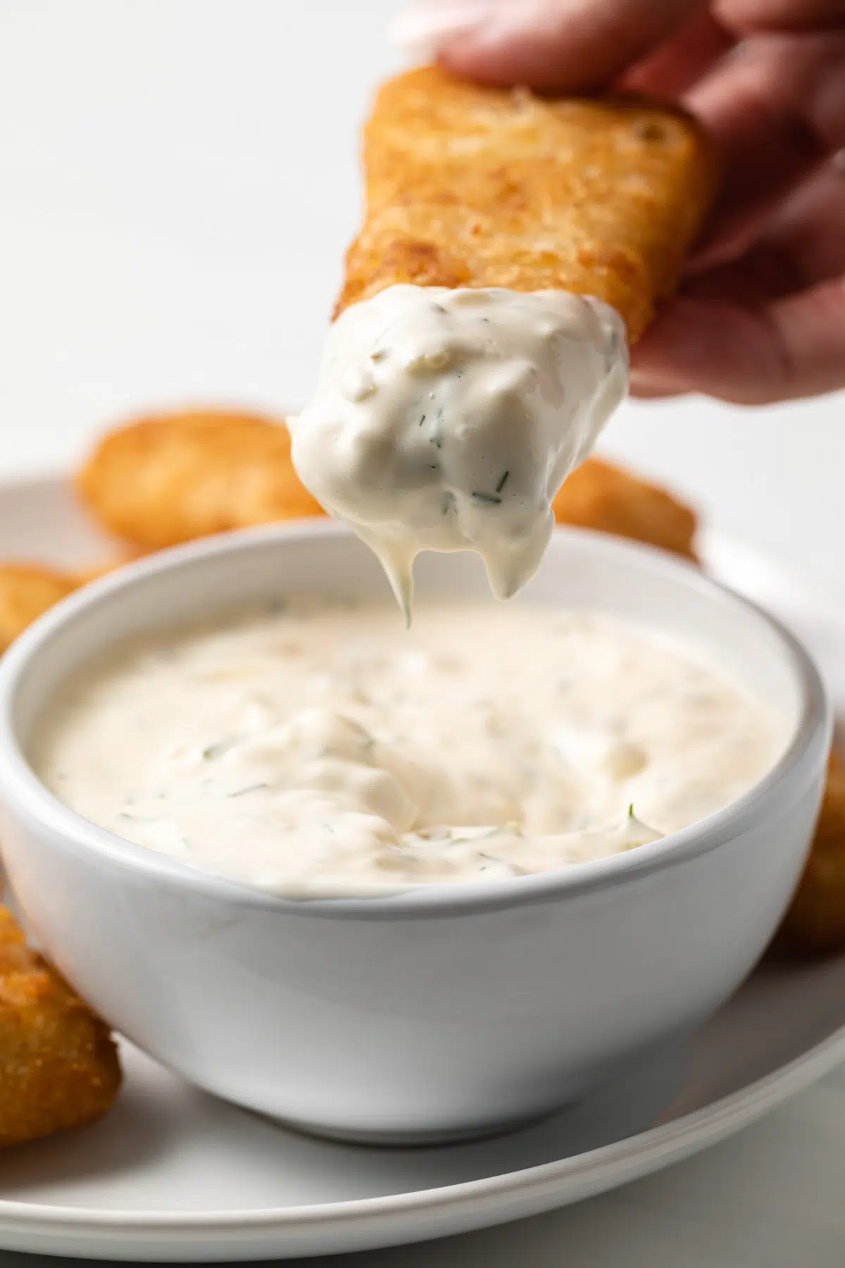 Fish fillet dipped in tartar sauce.