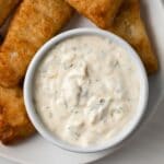 Tartar sauce in white bowl with fish fillets.