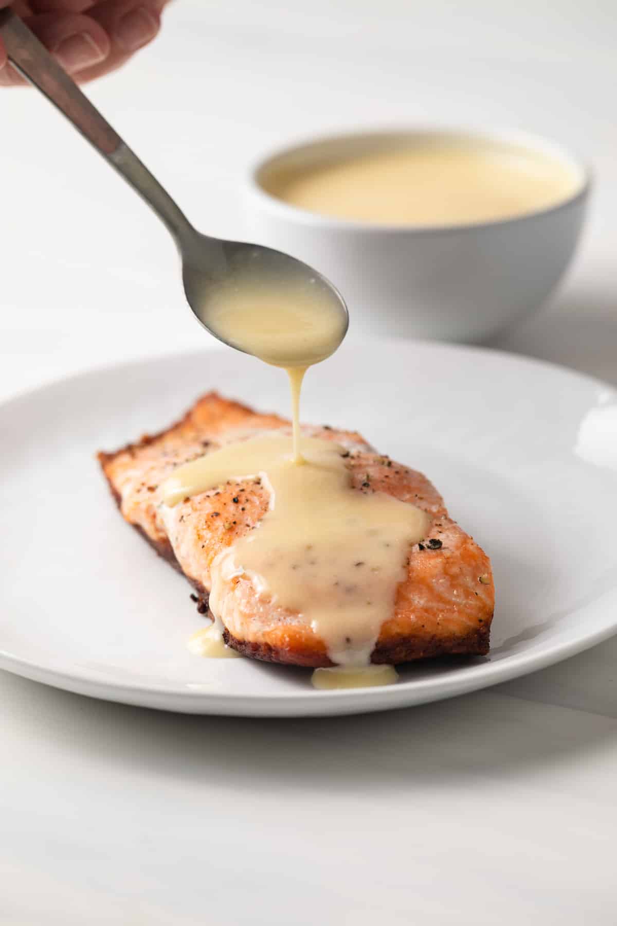 Beurre blanc sauce spooned over salmon.