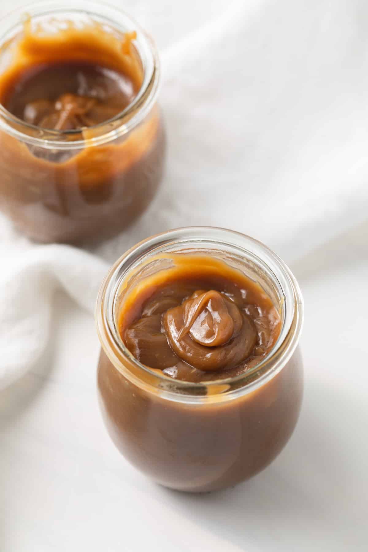 Angled view of butterscotch sauce in glass jar.