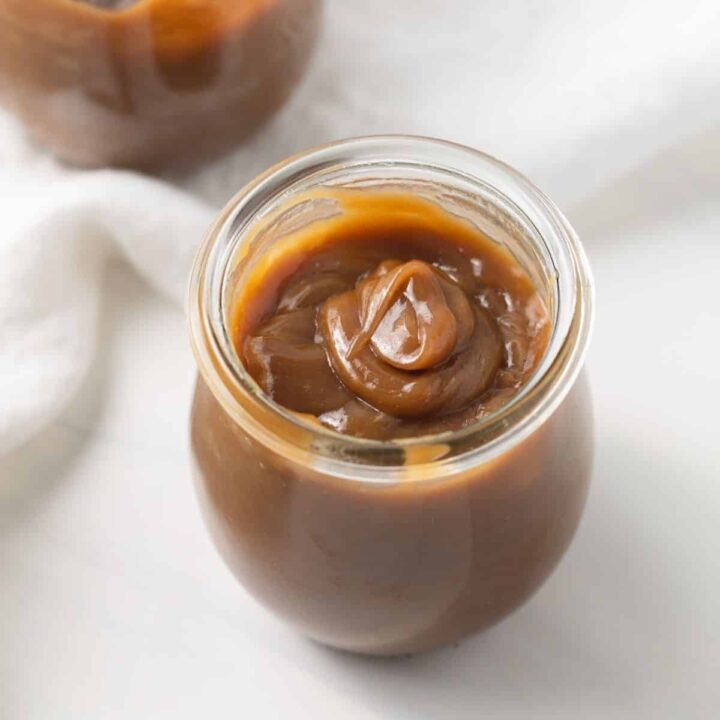 Angled view of butterscotch sauce in glass jar.