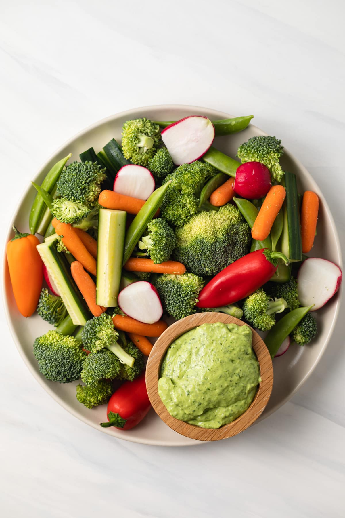 Green goddess pesto sauce in a bowl with fresh veggies on the side.